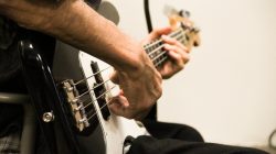 close_up_of_man_playing_bass_guitar_596432
